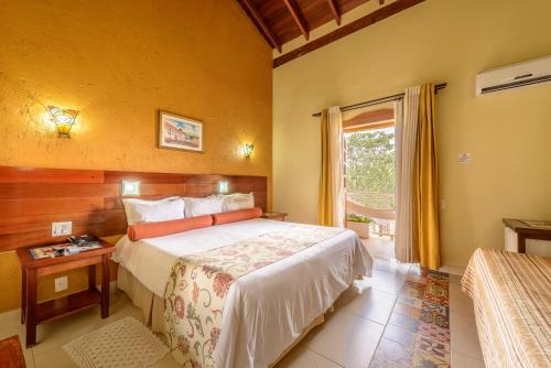 a hotel room with a bed and a window at Pousada dos Pireneus in Pirenópolis