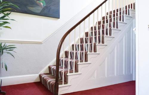 a staircase in a house with a red carpet at Dale Street Apartments Suite in Leamington Spa