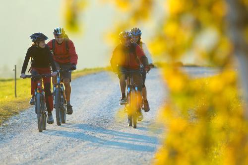 a group of people riding bikes down a dirt road at Apartmajsko naselje Ribniško Pohorje in Ribnica na Pohorju