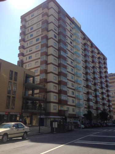 a tall building with a car parked in front of it at Vasco da Gama in Póvoa de Varzim