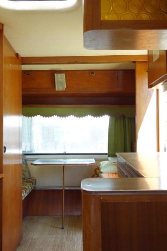 a small kitchen with a table and a window at Camping Pod Żaglem in Mielno