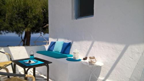 a patio with a blue couch and a table at Bellevue Village ''Αdults Only'' in Agia Pelagia