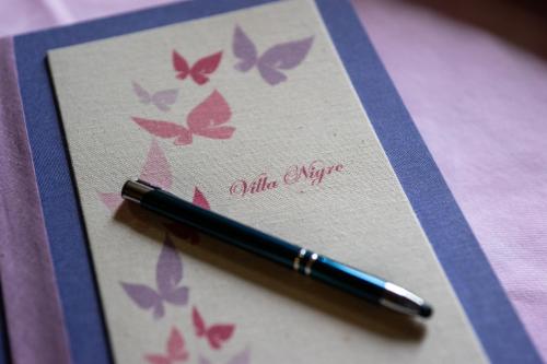 a pen sitting on top of a card with butterflies at Villa Nigro in Laureana Cilento