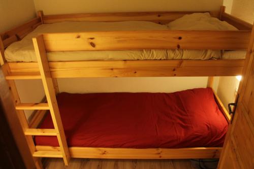 サン・ジェルヴェ・レ・バンにあるLe Grand Panorama (Apt. 410)の木製の二段ベッド(赤いシーツ付)