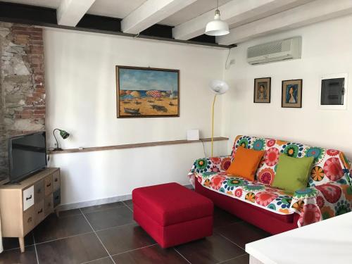 a living room with a couch and a tv at Il Vecchio Studio in Pietrasanta