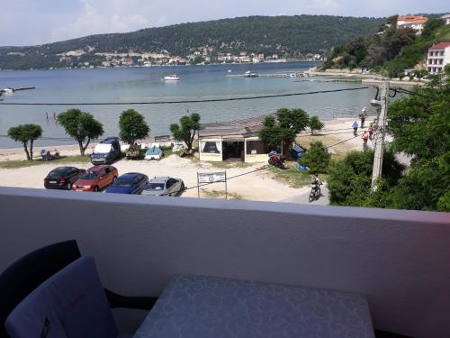 a balcony with a view of a beach and a body of water at Apartmani Premijer-Rab in Supetarska Draga
