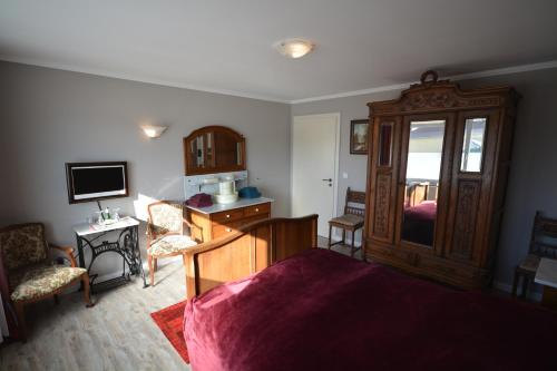 a room with a bed and a desk and a television at Sieben-Berge-Haus in Brüggen