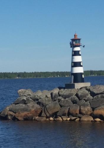 a lighthouse on a rocky island in the water at Kallaxgårdshotel/apartment, Luleå in Luleå