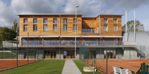 a building with a tennis court in front of it at Esmarin wellness hotel in Mníšek pod Brdy