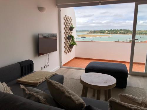 a living room with a couch and a view of the ocean at Ria Sunset House Alvor in Alvor