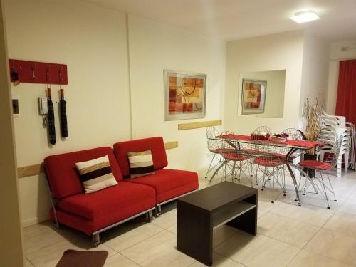 sala de estar con sofá rojo y mesa en Hipolito en Villa Carlos Paz
