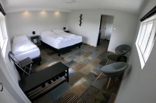 a bedroom with two beds and a desk and a table at Hamrar in Einarsstaðir