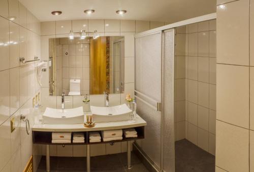 y baño con lavabo y espejo. en Hotel Taypikala Machupicchu, en Machu Picchu
