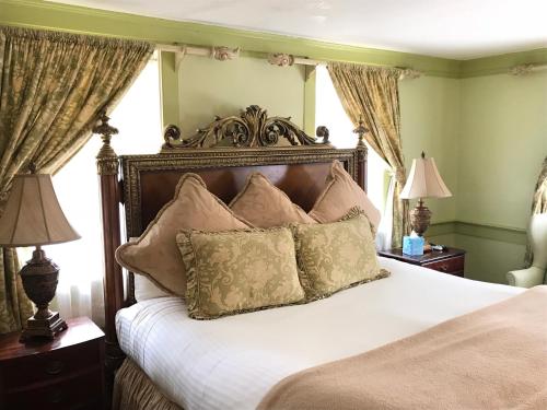 a bedroom with a large bed with white sheets and pillows at Admiral Farragut Inn in Newport