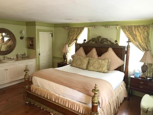 a bedroom with a large bed and a mirror at Admiral Farragut Inn in Newport