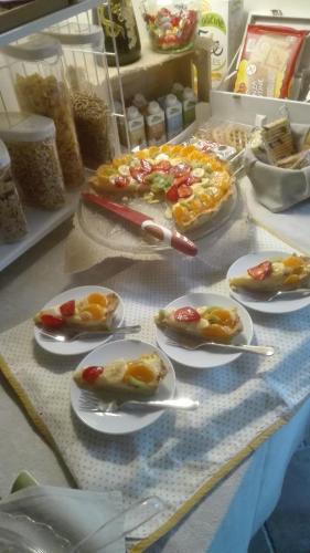 a table topped with plates of food with tongs at B&B Borgo Arcadia in Poiana Maggiore