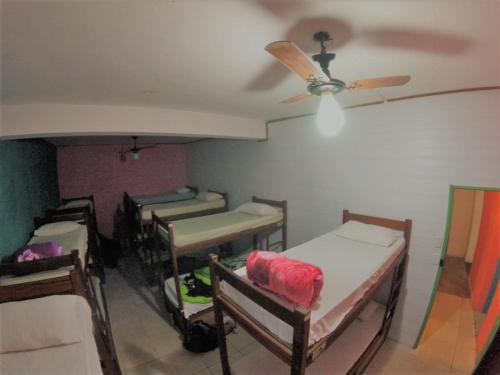 a room with several beds and a ceiling fan at Vibe Hostel Paraty in Paraty