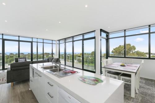 a kitchen and living room with a lot of windows at Whitewater Apartment 101 in Torquay