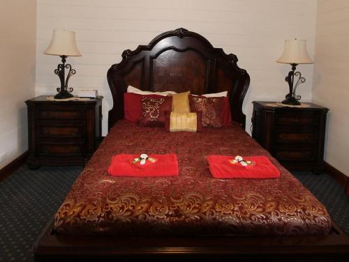 a bedroom with a large bed with two red pillows at Kerrellie Cottages 2, 4 & 8 Reid Street in Strahan