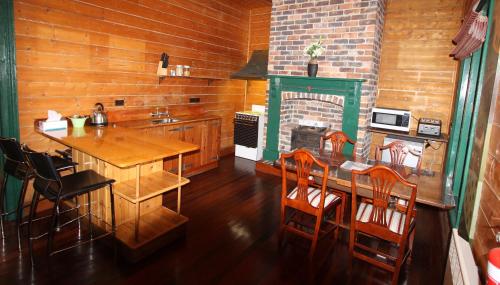 a kitchen with a table and a fireplace at Kerrellie Cottages 2, 4 & 8 Reid Street in Strahan