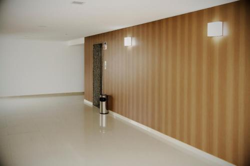 a hallway with a trash can next to a wall at Hotel Atlântico in Guarapari