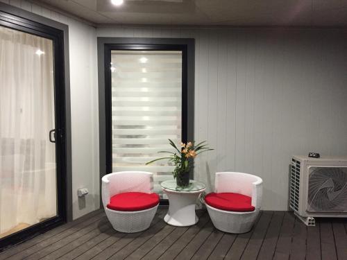 three chairs with red cushions sitting in a room at Apartments in Phillip Island Towers - Block C in Cowes