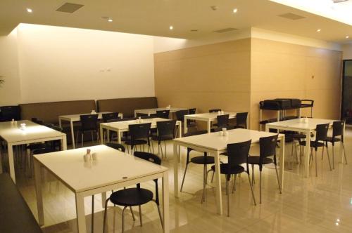 une salle à manger avec des tables et des chaises blanches dans l'établissement Jinbao Hotel, à Kaohsiung