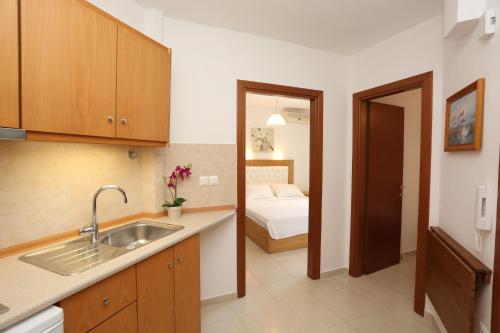 una cocina con fregadero y una cama en una habitación en Kastoria Hotel Apartments, en Chaniotis
