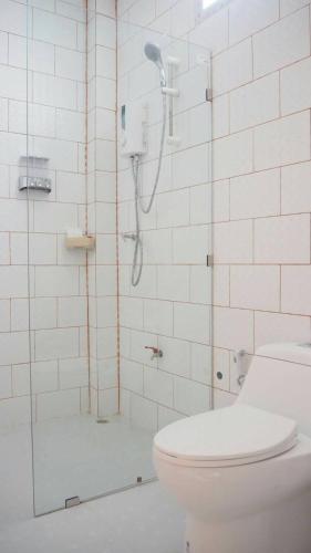 a bathroom with a shower with a toilet and a sink at Tamarind Lanta Resort in Ko Lanta