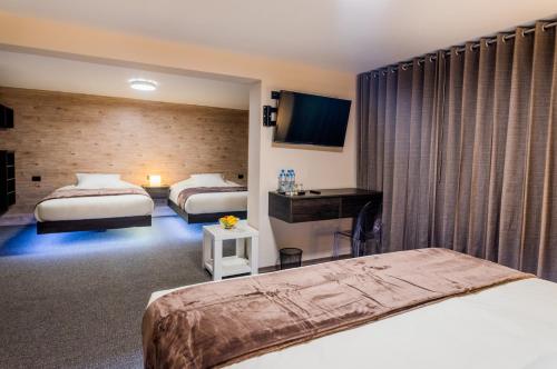 Habitación de hotel con 2 camas y escritorio en Hotel Viza, en Arequipa