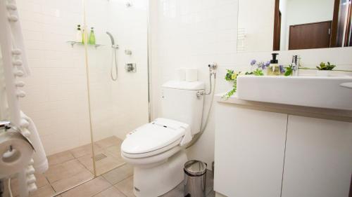 倶知安町にあるトショカンのトイレと洗面台を備えた白いバスルーム