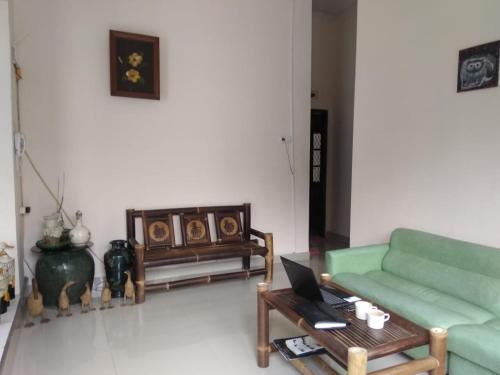 a living room with a green couch and a coffee table at Mone House Jogja in Yogyakarta