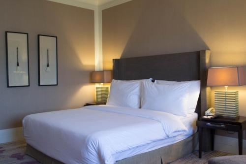 a bedroom with a large white bed with two lamps at I Hotel Batam in Nagoya