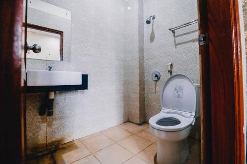 La salle de bains est pourvue de toilettes et d'un lavabo. dans l'établissement RedDoorz Plus @ Grand City Inn, à Makassar