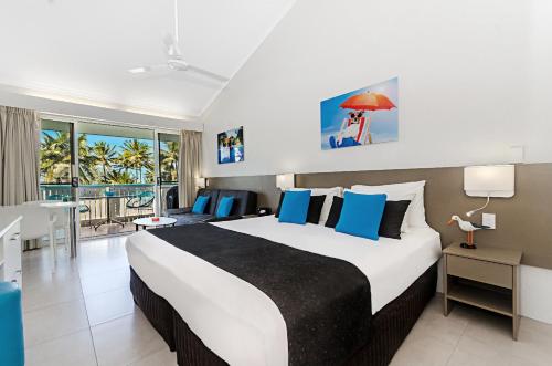 A bed or beds in a room at By The Sea Port Douglas