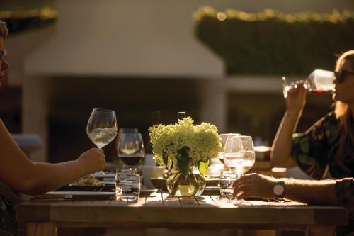 a group of people sitting around a table with wine glasses at Craggy Range Luxury Vineyard Retreat in Havelock North