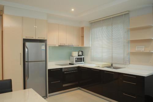 a kitchen with a refrigerator and a microwave at Jomtien Beach Penthouses Condo in Jomtien Beach