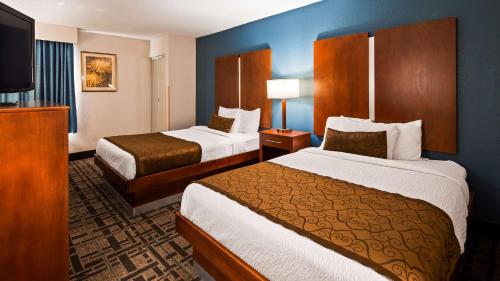 a hotel room with two beds and a flat screen tv at Best Western Plus Richmond in Sandston