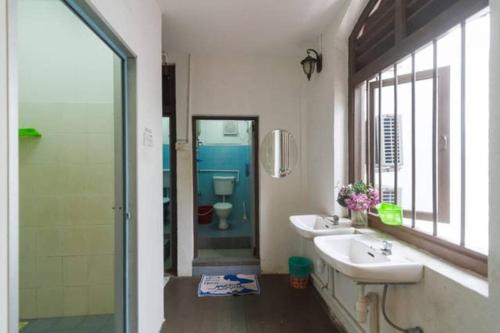 a bathroom with a sink and a shower and a toilet at Cocoa Mews Cafe and Homestay in George Town