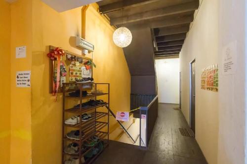 a hallway with yellow walls and a shelf with shoes at Cocoa Mews Cafe and Homestay in George Town
