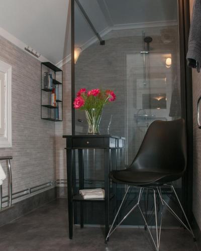 a black chair and a table with a vase of flowers at Ekeby i Bro in Bro
