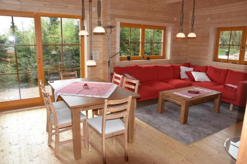 un soggiorno con divano rosso e tavolo di Erzgebirgsholzhaus am Lugstein a Kurort Altenberg