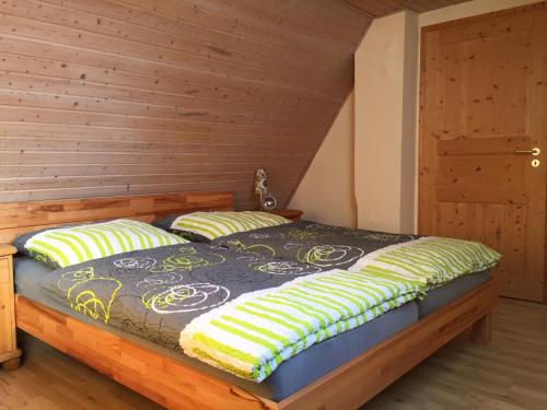 a bed in a room with a wooden wall at Ferienhaus Heinrich in Egloffstein