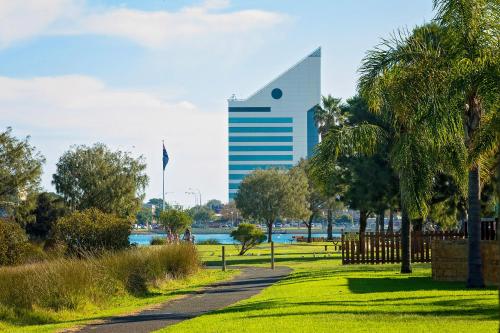 a large green building with trees and palm trees at Discovery Parks - Bunbury Foreshore in Bunbury