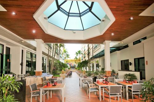 a restaurant with tables and chairs and a glass ceiling at Tara Angkor Hotel in Siem Reap