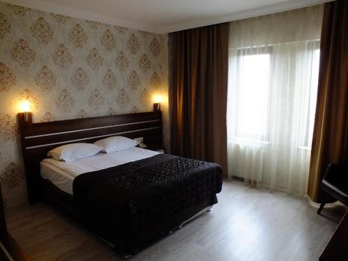 a bedroom with a large bed and a window at Lifos Hotel in Kayseri