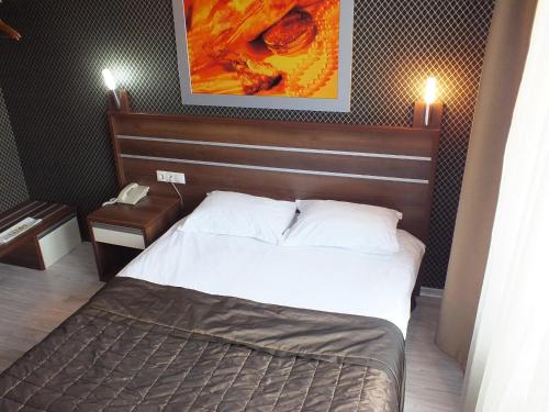 a hotel room with a bed and a phone at Lifos Hotel in Kayseri