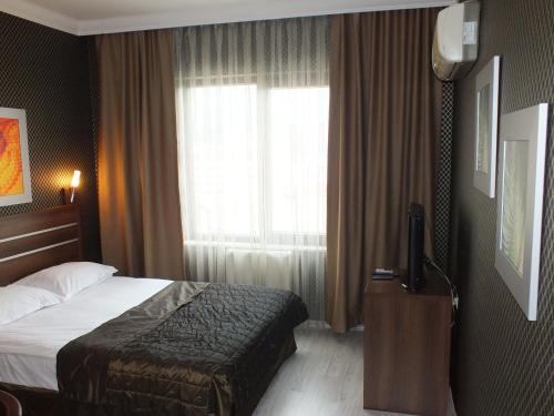 a hotel room with a bed and a window at Lifos Hotel in Kayseri