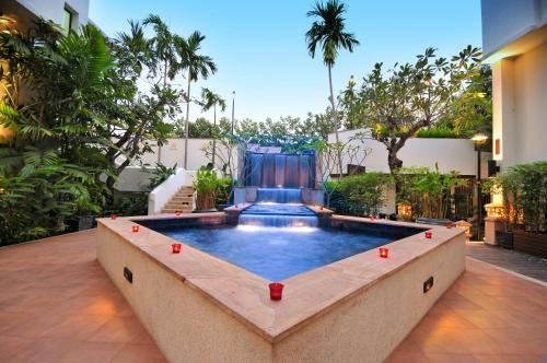 a pool in the middle of a courtyard with trees at Tara Angkor Hotel in Siem Reap