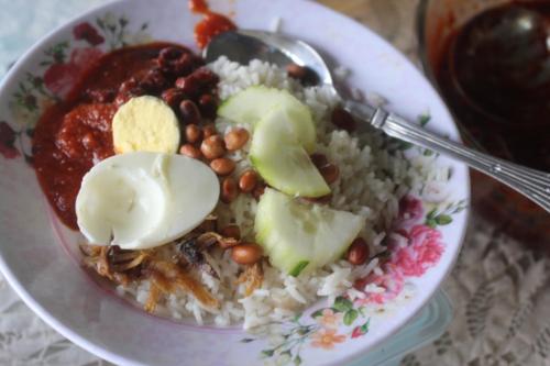 a plate of food with rice and beans and a spoon at Homestay Damai Sri Kota in Kepala Batas